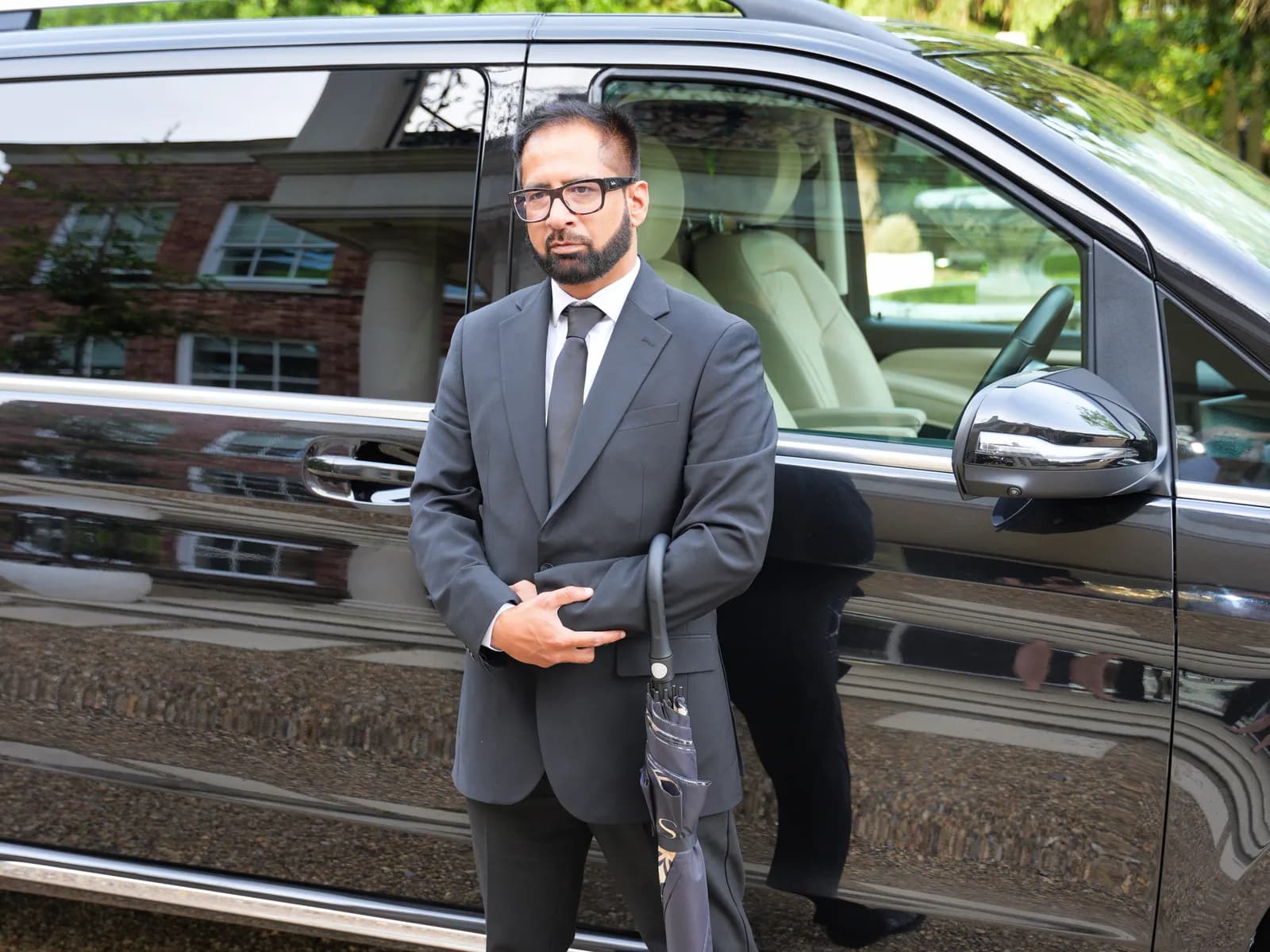 Khawar Siddiqui, founder of DRVSTAR, standing beside a black Mercedes-Benz V-Class