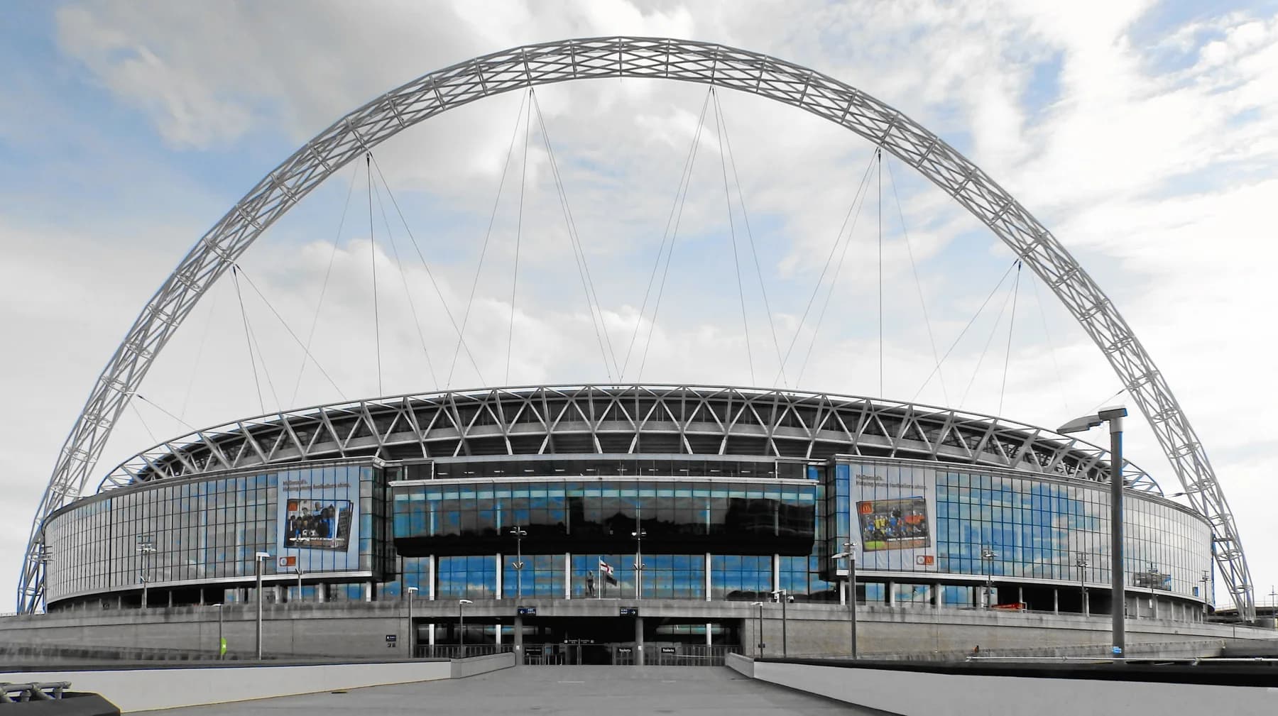 Wembley Stadium in London, its iconic white steel arch rising over the full stadium facade