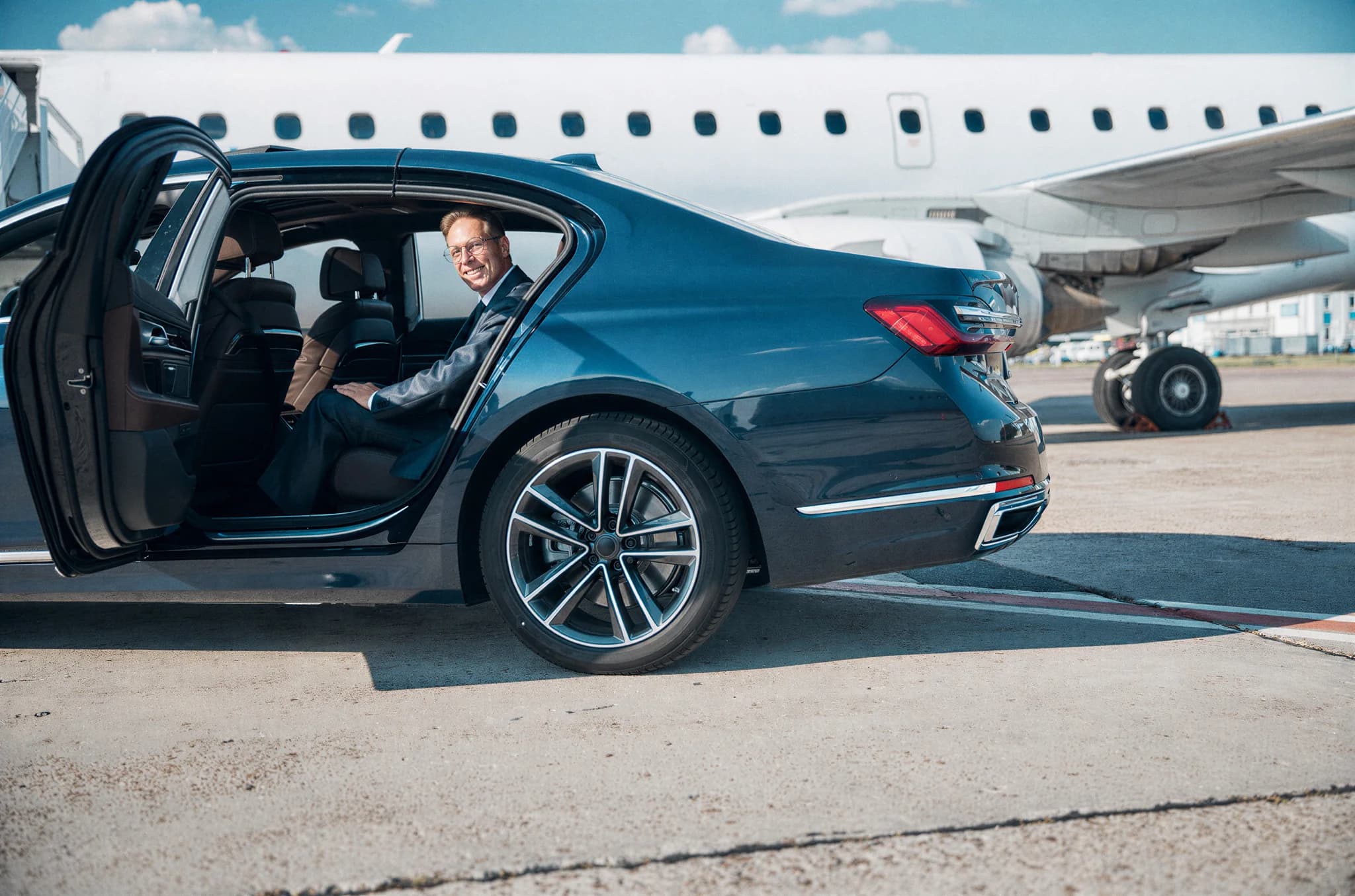 Passenger stepping from a chauffeur-driven car directly to the aircraft steps on the tarmac