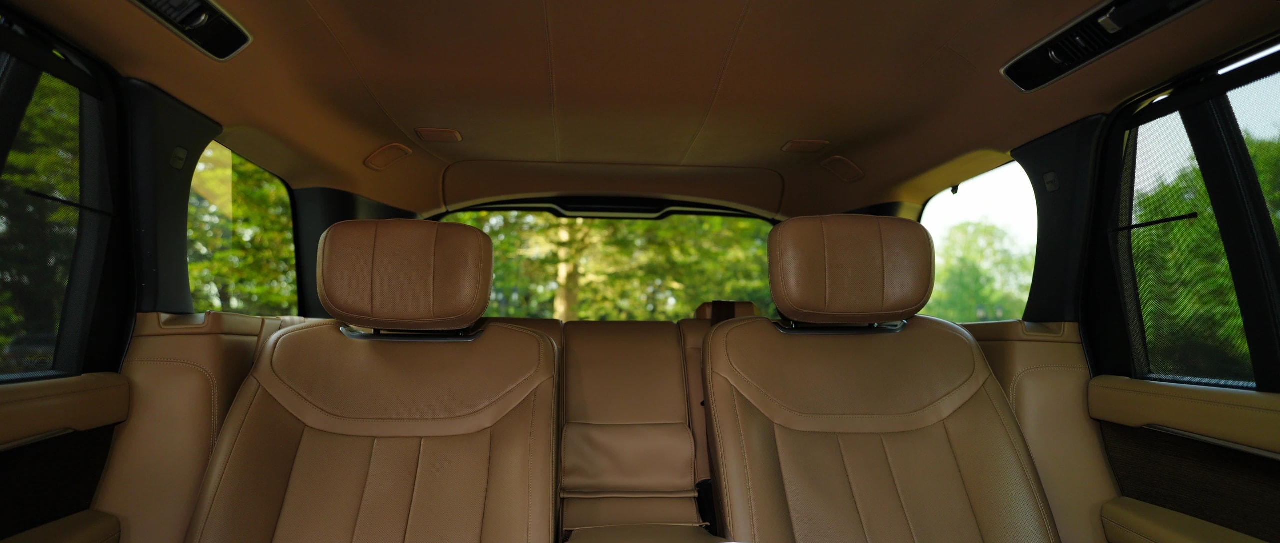 The tan leather rear cabin of a DRVSTAR Range Rover, seen from the boot