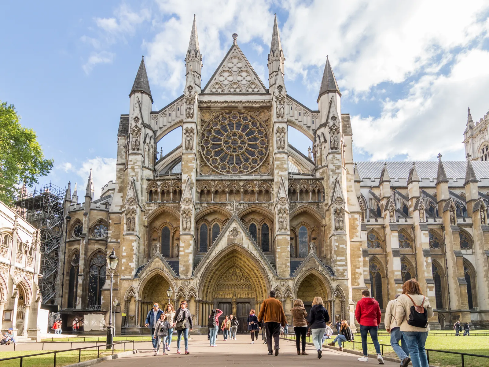 Visitors approaching the north front of Westminster Abbey on a sunny afternoon